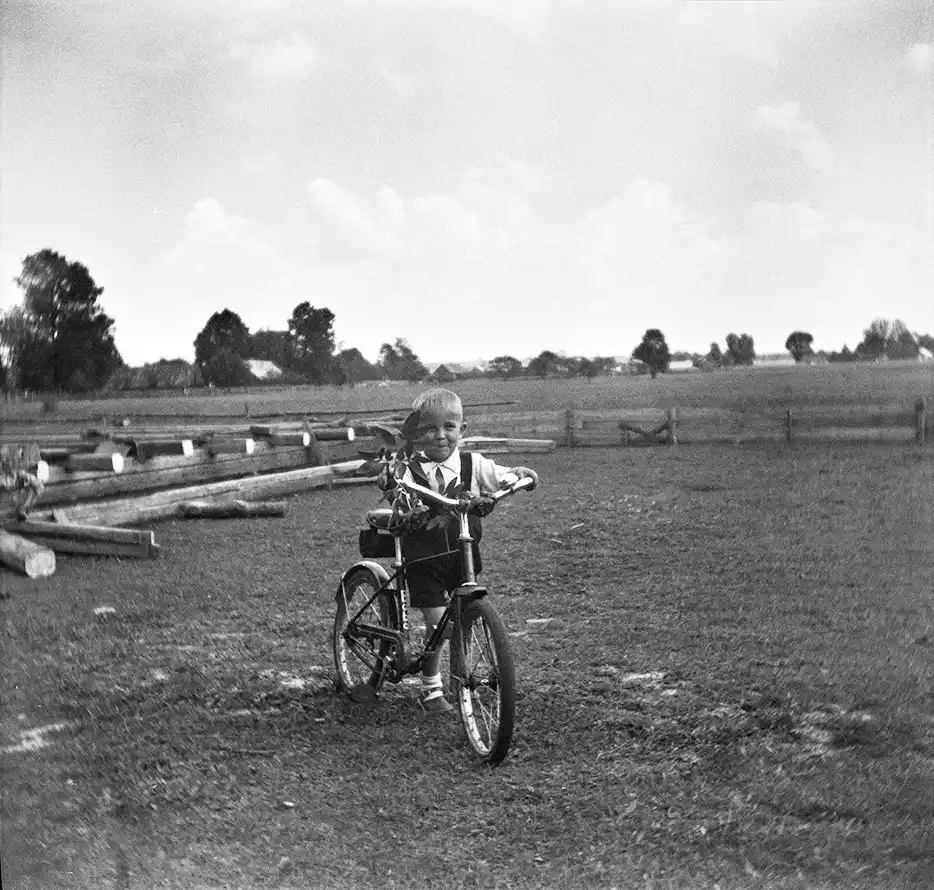 portret chłopca na rowerze, w tle sceneria wiejska