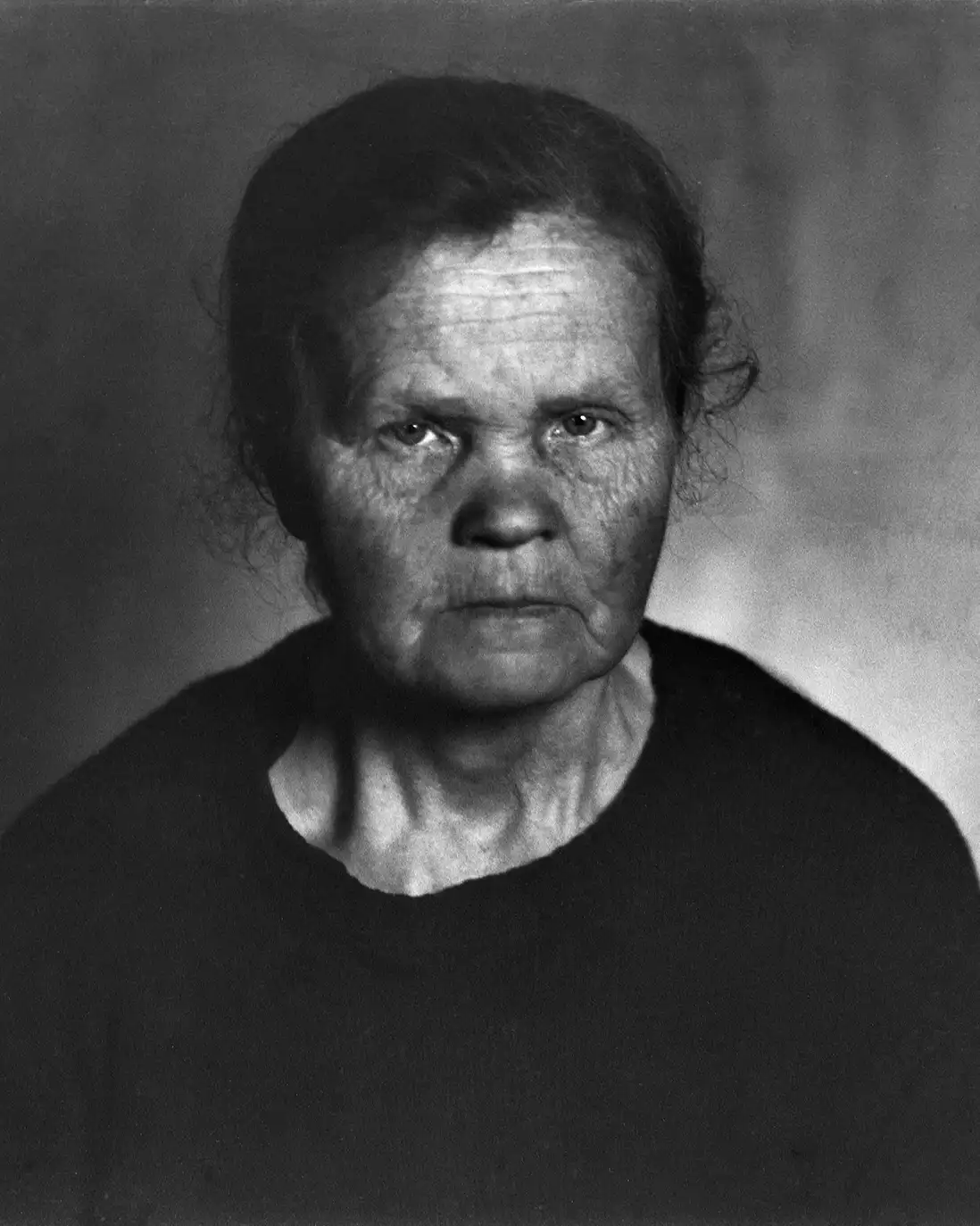 starsza kobieta w ciemnym ubraniu, portret studyjny, fotografia niedoświetlona