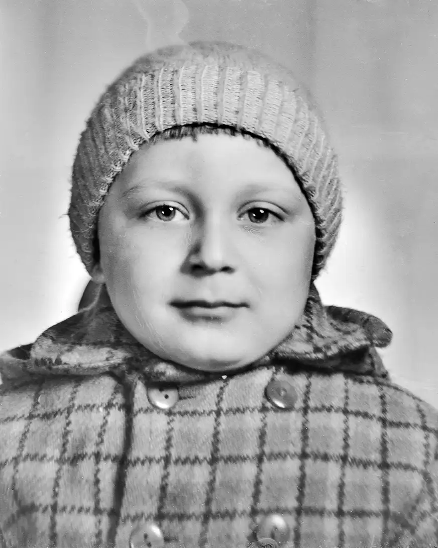 chłopczyk w czapce i kraciastej kurtce, portret studyjny