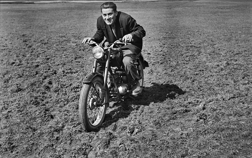 mężczyzna jedzie po trawie na motorze